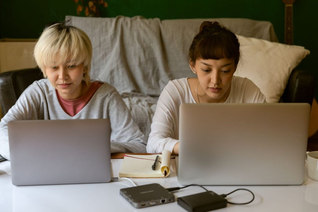 Hai học viên cùng làm bài trên laptop